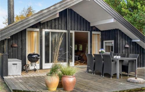 a black house with a deck with a grill at Holiday Home Ringvejen Iii in Rømø
