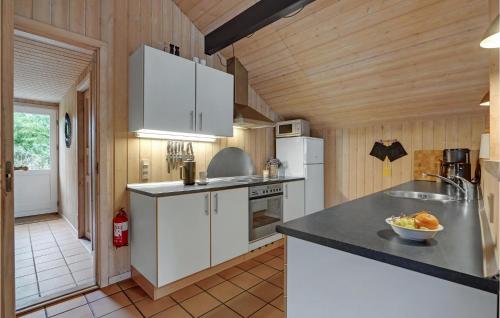 Una cocina con gabinetes blancos y encimera. en Holiday Home Ringvejen Iii, en Bolilmark
