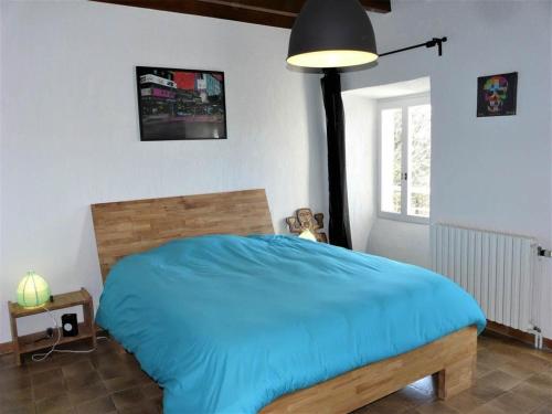 une chambre avec un lit bleu et une fenêtre dans l'établissement Domaine Sainte Germaine chambre d'hôte Stevenson, à Luc