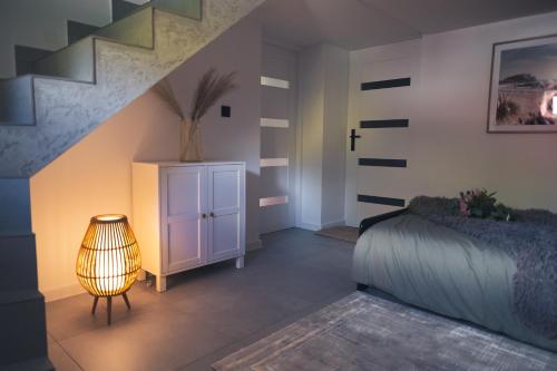 a bedroom with a bed and a table with a lamp at Zielony Apartament in Bachowice