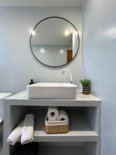 a bathroom with a white sink and a mirror at Eretria Lofts in Eretria