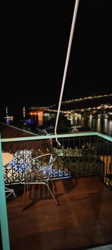 a deck of a ship at night with a table and chairs at 89 Steps Symi in Symi