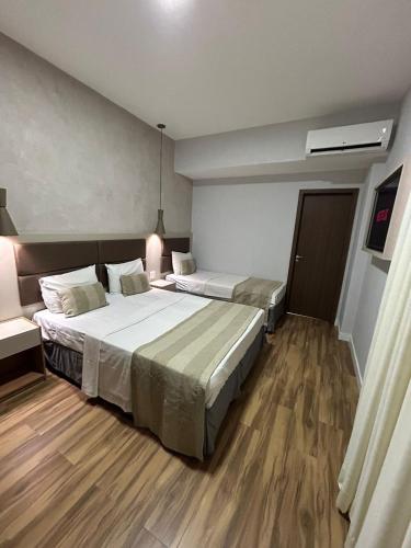 a hotel room with two beds in a room at Residencial Sausalito in Rio de Janeiro