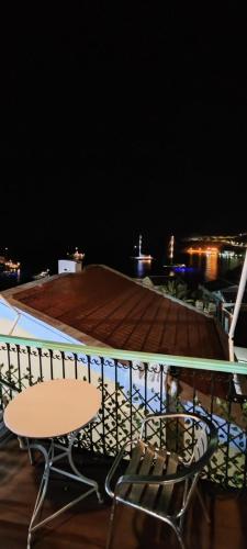 a table and chairs on a balcony at night at 89 Steps Symi in Symi