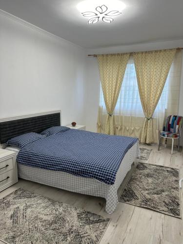 a bedroom with a bed and a window with curtains at Casa Grande in Făgăraş