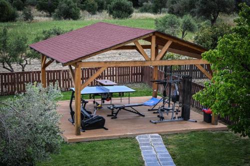 a wooden gazebo with a table and a gym at Vallian Village Hotel in Paradeísion