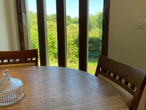 une table en bois avec un récipient en verre au-dessus dans l'établissement Maison en colombage - Les Iris, à Le Pré-dʼAuge