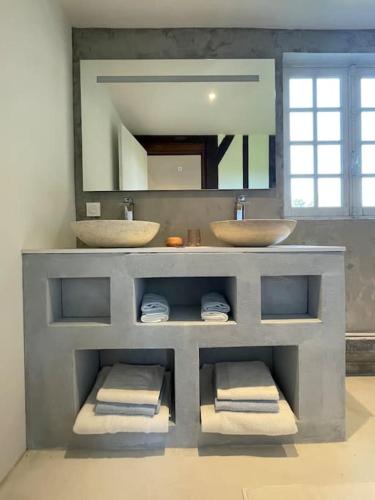 une salle de bain avec deux lavabos et deux miroirs dans l'établissement Maison en colombage - Les Iris, à Le Pré-dʼAuge