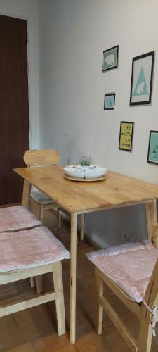 a wooden table with two chairs and a plate on it at Ban View Viman Condo in Hua Hin