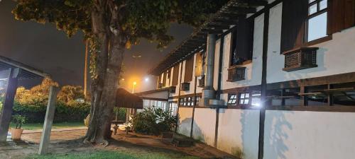 a building with a tree in front of it at night at Pousada dos Veleiros in Nova Almeida