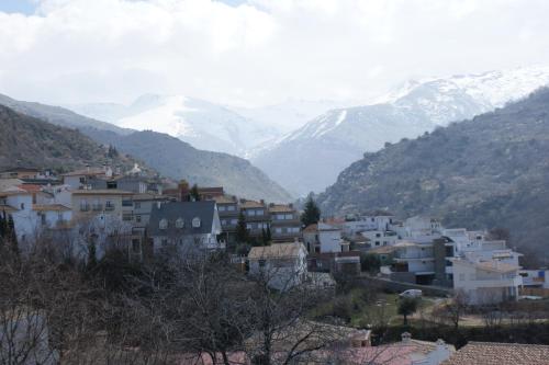 a town with snow capped mountains in the background at Hotel Juan Francisco in Güéjar-Sierra