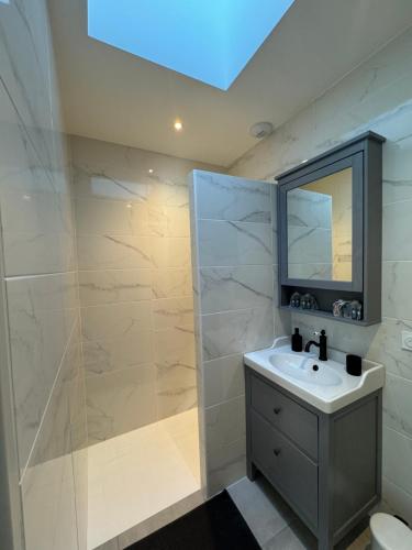 une salle de bain avec un lavabo et une douche dans l'établissement Villas Ambiance 21 Elégance Méditerranéenne à Portiragnes entre Terre et Mer Villa Séréna, à Portiragnes