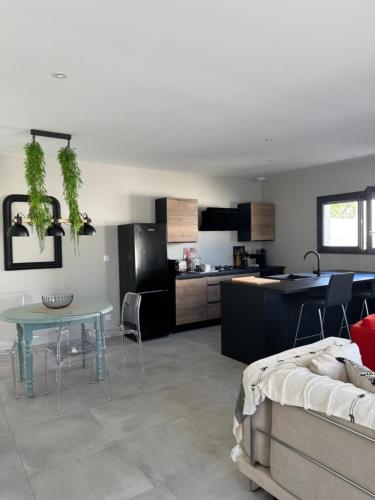 un salon avec une table et une cuisine dans l'établissement Villas Ambiance 21 Elégance Méditerranéenne à Portiragnes entre Terre et Mer Villa Séréna, à Portiragnes