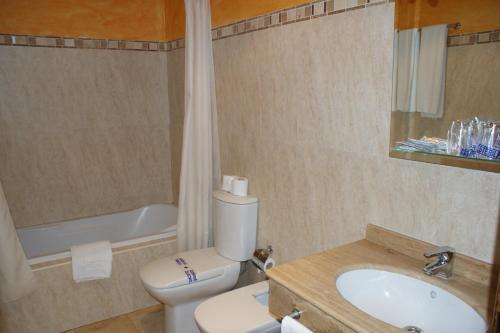een badkamer met een toilet, een wastafel en een bad bij Hotel Juan Francisco in Güéjar-Sierra