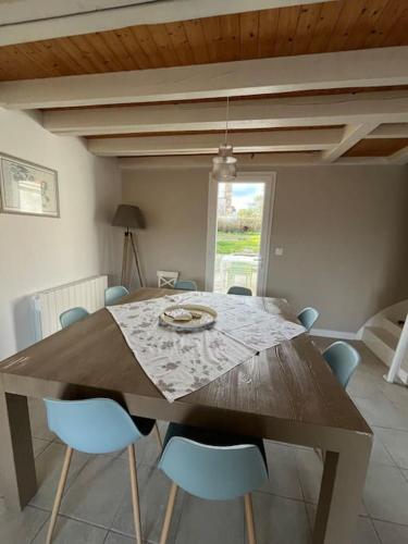 d'une table à manger entourée de chaises bleues. dans l'établissement Villa La Famille plage à pied, à Marennes