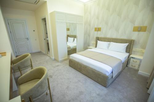 a bedroom with a bed and two chairs in it at Ketrin Hotel Restaurant in Ayntʼapʼ