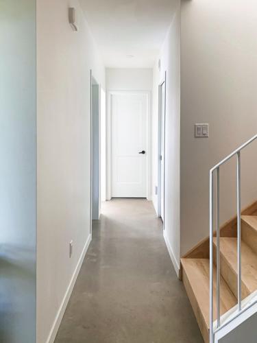 a hallway with stairs and a white door at Chalet au bord du lac in Saint Adolphe D'Howard