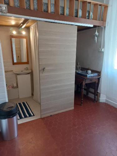 La salle de bains est pourvue d'une porte blanche et d'une table. dans l'établissement les pieds dans l'eau, à La Seyne-sur-Mer