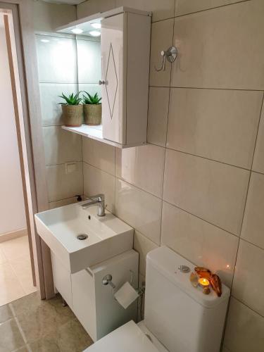 a bathroom with a toilet and a sink and a mirror at Irina's House in Sitia
