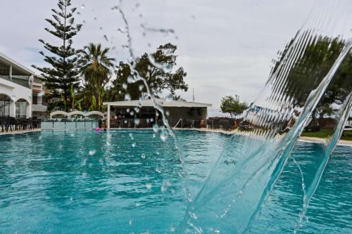 a fountain in the middle of a swimming pool at Vallian Village Hotel in Paradeísion