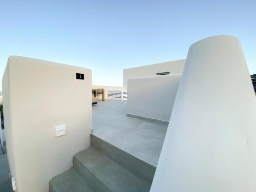 a stairway leading up to a white building at Nohēme Luxury Suites in Vourvoulos