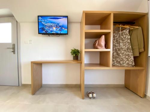 a shelf with a tv on a wall at Nohēme Luxury Suites in Vourvoulos