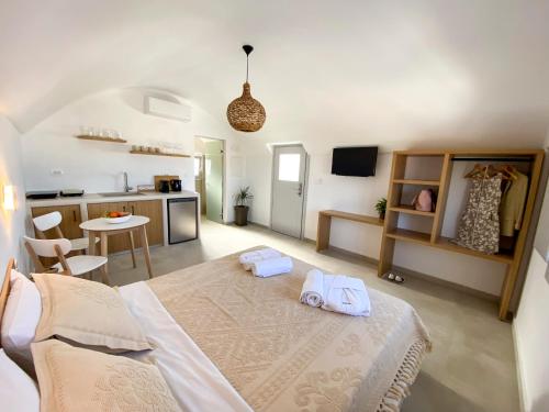 a bedroom with a large bed and a kitchen at Nohēme Luxury Suites in Vourvoulos