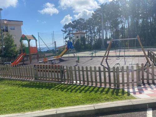 a park with a playground with slides and swings at Estupendo apartamento en San Vicente do Mar O Grove in San Vicente do Mar
