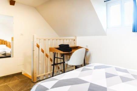 a bedroom with a desk with a chair and a bed at Gite Bonheur et Charme Spa-Sauna forfait 2h inclus in Kintzheim