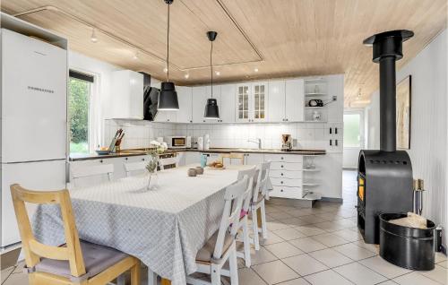 a kitchen with a table with chairs and a stove at Holiday Home Koubjerg Iii in Toftum