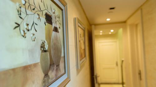 a hallway with a picture of a vase on the wall at Duplex-Nyoum New Cairo in Cairo
