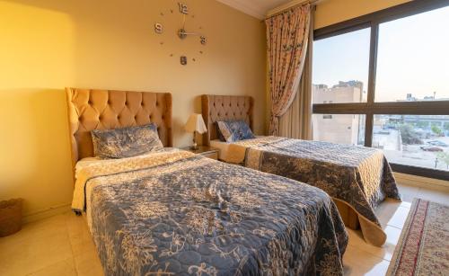 a hotel room with two beds and a window at Duplex-Nyoum New Cairo in Cairo