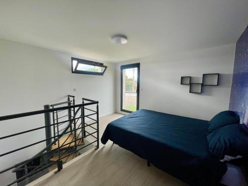 una camera da letto con un letto blu e una finestra di Bessan 2 Ch 5 personnes wifi parking calme a Bessan