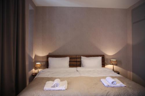 a bedroom with a bed with two towels on it at Family Hotel Stumari in Tbilisi City