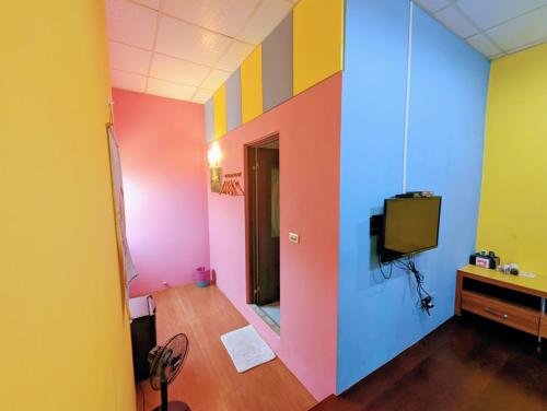 a room with colorful walls and a tv in it at 小琉球陽光藍海民宿 in Xiaoliuqiu