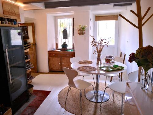 une salle à manger avec une table et des chaises blanches dans l'établissement Ma maison est la vôtre, à Castanet