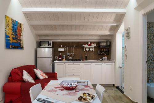 a living room with a red couch and a kitchen at Ninè in Pozzallo
