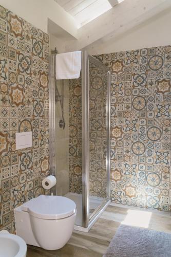 a bathroom with a toilet and a shower with tiles at Ninè in Pozzallo