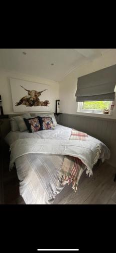 a bedroom with a bed with a painting on the wall at Millburn Mini Farm in Kilwinning