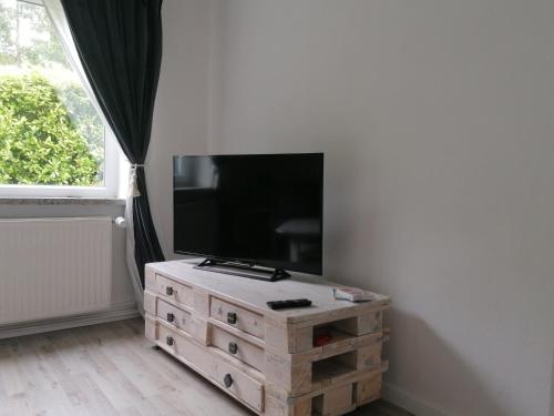a flat screen tv sitting on top of a wooden dresser at Walls 1 in Wallsbüll
