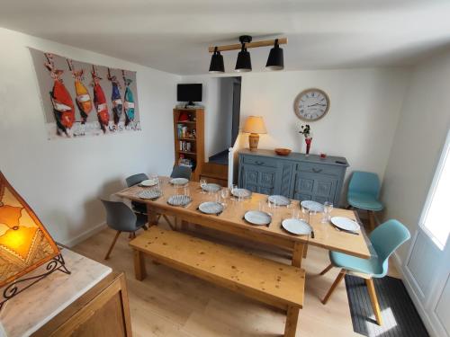 une salle à manger avec une table et des chaises en bois dans l'établissement MER 12 à 14 pers L'Aiguillon sur mer, à LʼAiguillon-sur-Mer