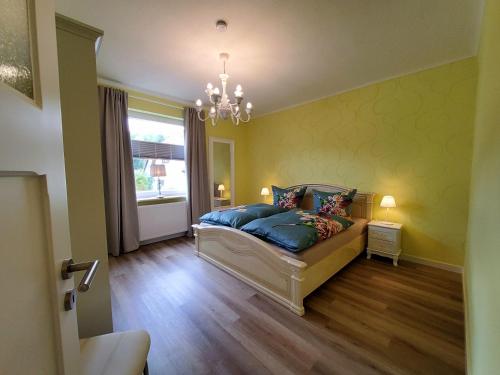 a bedroom with a bed with blue pillows and a window at Ferienwohnung Nonnenbergblick in Cabarz