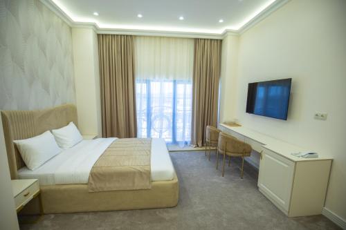 a hotel room with a bed and a desk and a television at Ketrin Hotel Restaurant in Ayntʼapʼ
