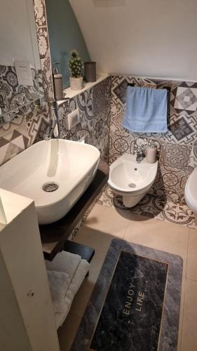 a bathroom with a white sink and a toilet at Casa Porta Nuova in Bisceglie