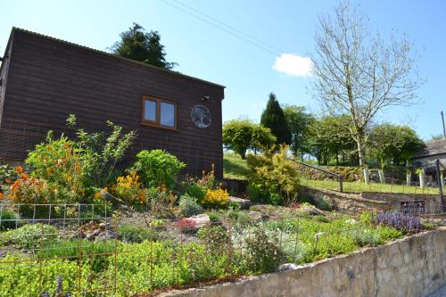 a house with a garden in front of it at The Warren Lodge Cabin at Ashes Farm, near Settle in Settle