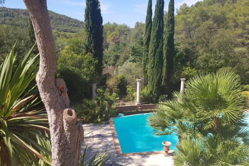 a pool in the middle of a garden with trees at Luxueux Cocon avec parc paysagé avec piscine XXL à débordement, mer et plages 15 minutes in Pierrefeu-du-Var