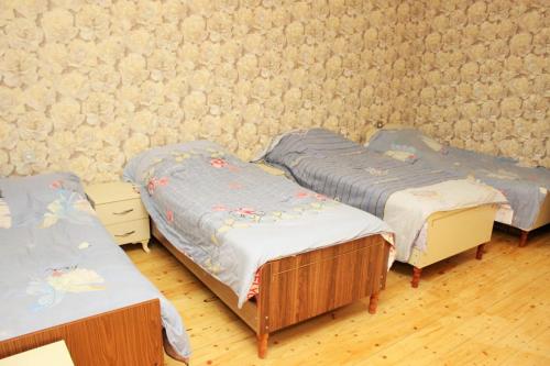 a room with three beds and a wall at Daire in Ganja