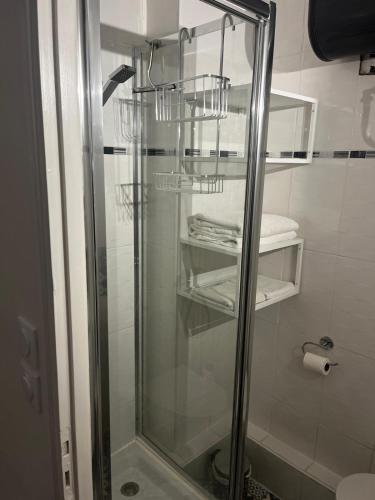 La salle de bains est pourvue d'une cabine de douche en verre et de serviettes. dans l'établissement Village Naturiste Héliopolis FGH, au Cap d'Agde