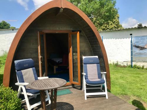 a circle tent with two chairs and a table on a deck at Glampingpod in Loitz