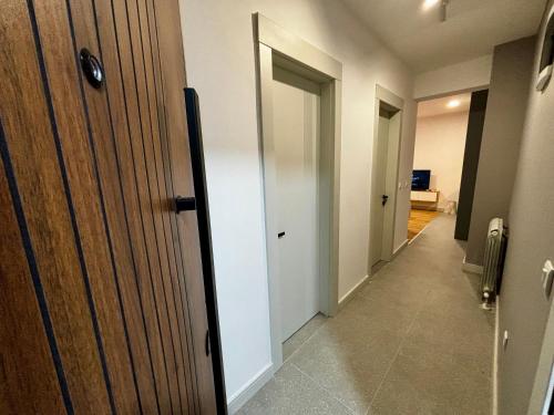 a hallway with a wooden door and a hallway with a room at Zafiro Apartment in Kolašin
